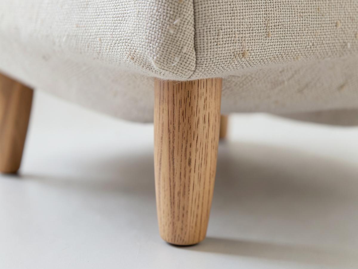 Detalle de la pata de madera maciza y del tapizado de tela